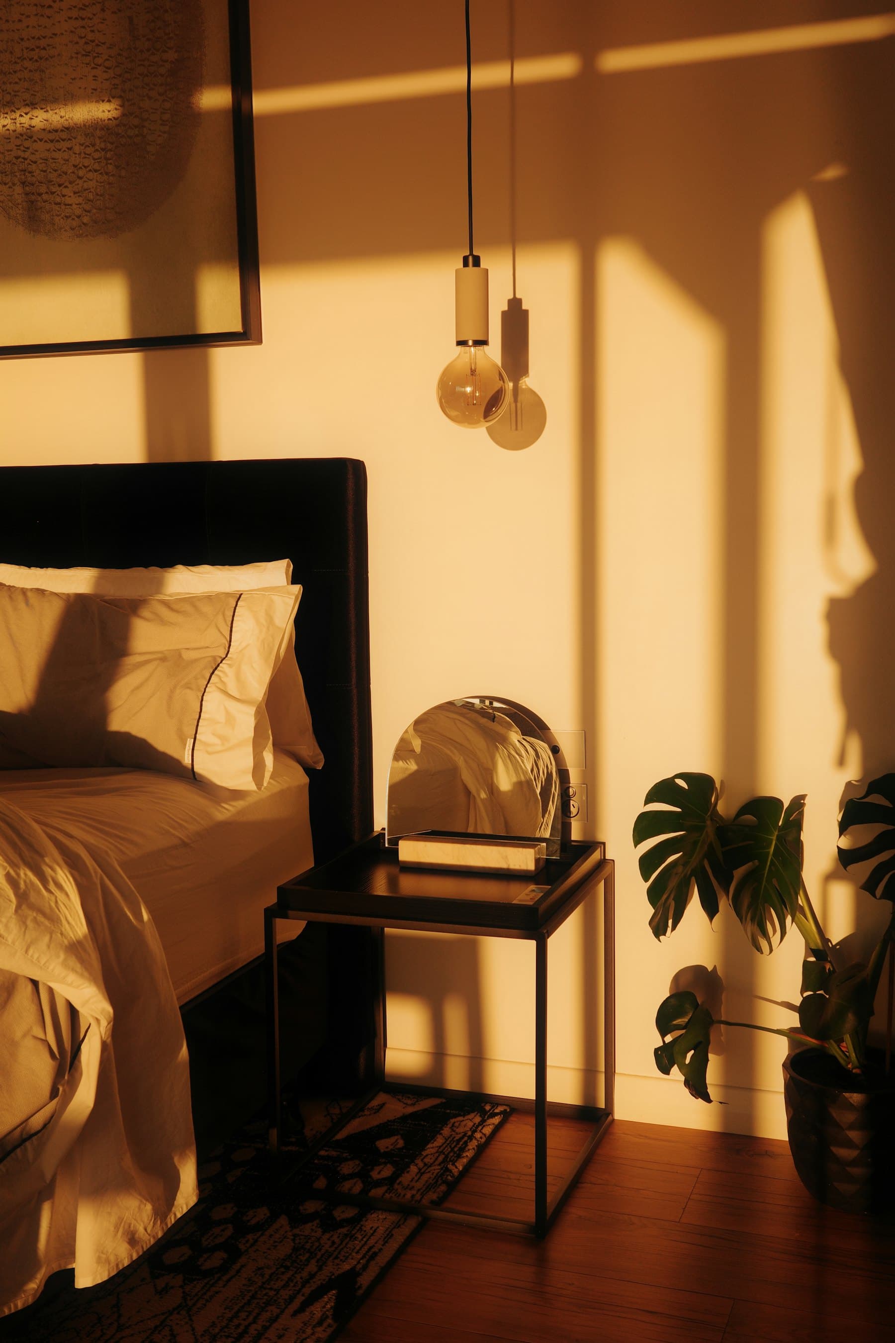 A bedroom in warm evening light, with the indoor unit sited above the door